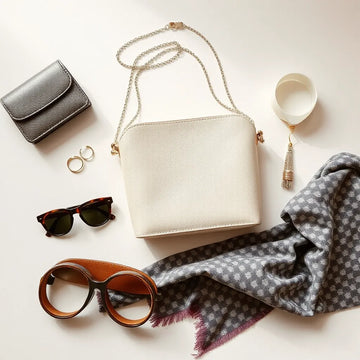Trendy accessories laid out neatly: necklace, earrings, rings, sunglasses, belt, bag, and scarf.