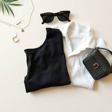 A curated set of trendy accessories—necklace, earrings, belt, sunglasses, and mini bag—arranged on a neutral surface